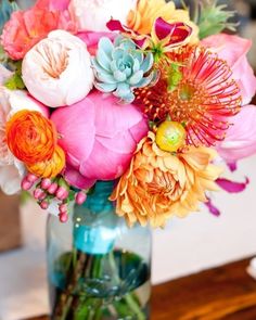 a vase filled with lots of flowers on top of a wooden table next to an instagram page