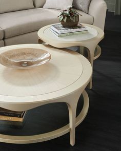 two tables with books on them in front of a couch and coffee table next to each other