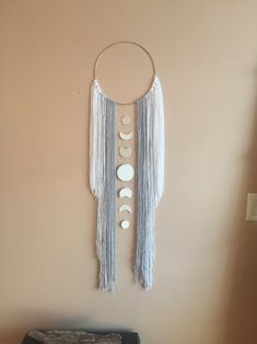 a wall hanging with three phases of the moon and crescents on it in a room