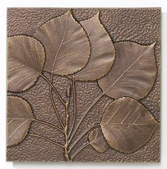 a close up of a decorative tile with leaves on it