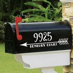 a mailbox with the number 925 and an arrow on it is next to a brick wall