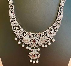 This South Indian Haaram features a stunning peacock design with CZ American Diamonds, making it the perfect accessory for any marriage, party, or as a gift for HER. The medium size is versatile and ideal for pairing with Indian outfits like silk sarees or gowns. Expertly crafted for an elegant touch. This jewellery set includes a necklace, matching earrings and a maang tika. Jewellery Care- Keep the jewellery dry, avoid contact with perfumes and water. Elegant Bridal Necklace With Zari Work, Bollywood Bridal Necklace With Peacock Design For Celebration, Elegant Bridal Necklace With Motifs For Wedding, Festive Peacock Design Bridal Necklace For Reception, Elegant Bridal Necklace With Motifs For Festive Occasions, Festive Bridal Necklace With Elegant Motifs, Festive Elegant Bridal Necklace With Motifs, Silver Peacock Design Bridal Necklace, Silver Bridal Necklace With Peacock Design For Wedding