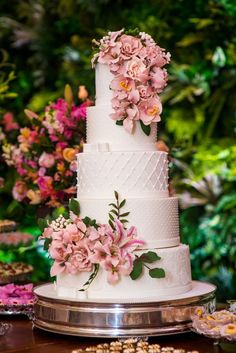 a white wedding cake with pink flowers on top