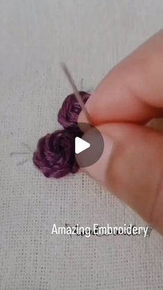 someone is crocheting with yarn and knitting needles to make a piece of fabric