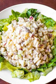 a white plate topped with lettuce and chicken salad