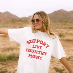 Support Live Music Shirt, Country Music Shirt, Country Concert TShirt, Country Music Tee, Western Graphic Tee, Country Music Gift .: 100% ring-spun cotton .: Medium fabric (6.1 oz/yd² (206.8 g/m .: Relaxed fit .: Sewn-in twill label Shipping & Processing:  Please allow 1-7 business days for processing. It may be processed sooner, and you will be updated as soon as it ships. Shipping can take anywhere from 2-5 business days.  Returns & Exchanges: We do not offer returns or exchanges due to items being made to order. Please refer to size chart to get the fit you want. If there is any problem with your order, please let us know within 2 weeks of receiving your item. Thanks for shopping with Daring & Darling! White Band Merch T-shirt For Music Festivals, White T-shirt With Text Print For Music Festivals, Cotton Slogan T-shirt For Music Festivals, White Text Print T-shirt For Music Festivals, Music Festival Concert T-shirt With Text Print, Text Print T-shirt For Music Festivals And Concerts, Text Print T-shirt For Concerts And Music Festivals, White Slogan T-shirt For Concert, Text Print T-shirt For Music Festival Concerts