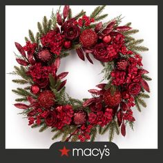 a christmas wreath with red flowers and greenery on the front, says macy's