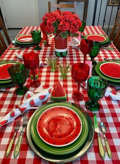 the table is set with watermelon plates and silverware