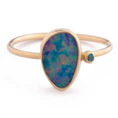 a gold ring with an oval blue opal