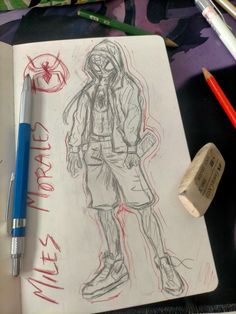 a drawing of a person with a hoodie on and some pens next to it