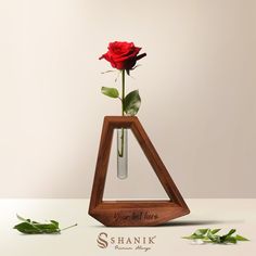 a single red rose in a glass vase with the name shanik written on it