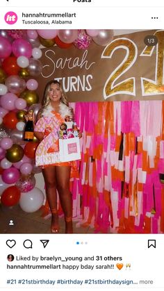 a woman standing in front of a wall with balloons and streamers on it's sides