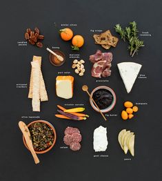 an assortment of cheeses and meats arranged in a circle on a black surface