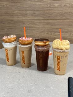 four different types of donuts and drinks on a table