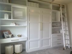 a white closet with shelves and ladders in the corner next to bookshelves