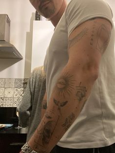 a man with tattoos on his arm in the kitchen