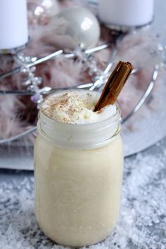 a glass jar filled with whipped cream and cinnamon on top of a marble countertop