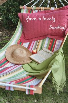 a striped hammock with a book and hat on it