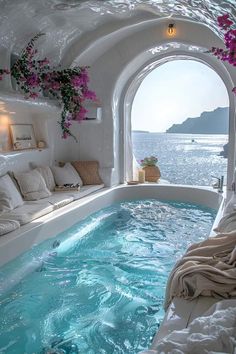 an indoor jacuzzi is shown with flowers in the window sill and couches