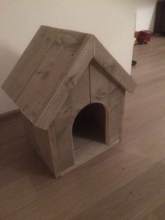 a dog house made out of wood on the floor