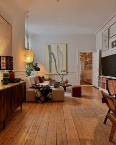 a living room filled with furniture and a flat screen tv on top of a wooden floor