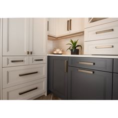 a kitchen with white cabinets and gray drawers