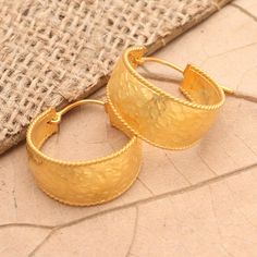 For simple charm and unfussy elegance look no further than Made Sri's classic hoop earrings. The Balinese artisan crafts the hoops from a wide band of 18k gold-plated sterling silver finishing the pair with a subtle hammered finish and saddleback closures.