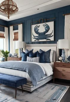 a blue and white bedroom with a bed, dressers, lamps and pictures on the wall