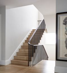 a stair case next to a painting on the wall and a framed photo in front of it