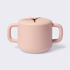 a pink coffee cup sitting on top of a white table