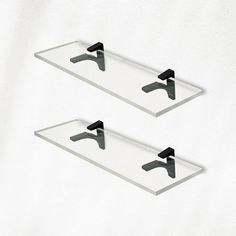 two glass shelfs with black handles on each side and one is holding a pair of faucets