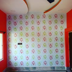 an empty room with red walls and floral wallpaper