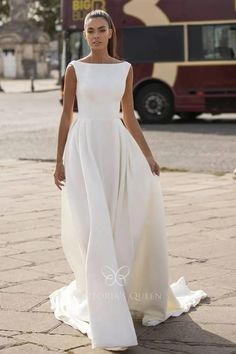 a woman in a white dress is walking down the street with her hands on her hips