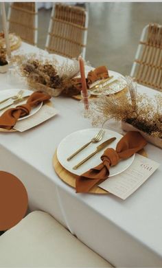 the table is set with gold and white place settings