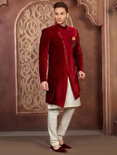 A Long and royal indian ethnic indian wear sherwani especially designed for men in order to make an occasion very especial. It is elegantly made with hands to bring about a feel about India. Look your best on your special day while you carry your sharp attitude with this indowestern sherwani paired with a churidar. Colored in oxford blue color and black embellished with woven work. Available with gold color cotton silk churidar. Slip on to some matching mojari and a matching safa to compleThis s Eid Velvet Fitted Bandhgala, Fitted Velvet Bandhgala For Eid, Velvet Long Sleeve Traditional Wear For Weddings, Velvet Bandhgala For Eid Festivities, Festive Velvet Fitted Sherwani, Fitted Velvet Kurta With Dabka Detailing, Fitted Velvet Kurta With Dabka Embroidery, Semi-stitched Velvet Kurta With Long Sleeves, Semi-stitched Velvet Long Sleeve Kurta