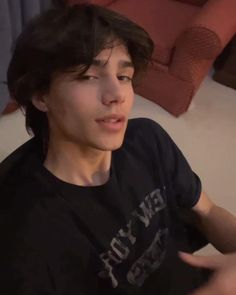 a young man sitting on top of a white couch