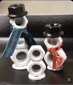 two snowmen made out of toilet paper and some ribbon on top of each other