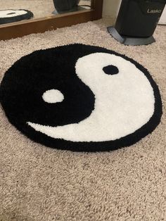 a black and white rug with a yin symbol on the floor in front of a mirror