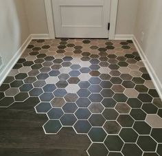 a bathroom floor with hexagonal tiles in grey and white, the door is open