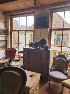 a living room filled with furniture next to a window covered in lots of clutter