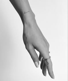 a woman's hand with a small tattoo on her left wrist and the word love is written in cursive writing