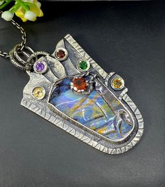 "Carved Australian Opal gemstone pendant necklace in sterling silver Hand-made Sterling Silver 925. Stones used: Australian Opal, Citrine, Amethyst, Garnet, Chrome Diopside Height - 2 1/4\" (with bail), Width - 1 1/4\" Chain length 20 inches Unique Handcrafted One-of a-kind Design Pendant Each Piece of Jewelry in my Collection is Absolutely One of a Kind! When you start wearing a piece of my jewelry you will fall in love with it more and more each day and feel that good Energy and Love that I pa Unique Silver Necklace With Rectangular Pendant, Artistic Hand Forged Sterling Silver Necklace, Artisan Sterling Silver Pendant Necklace, Artisan Sterling Silver Necklace For Gift, Sterling Silver Multi-stone Round Pendant Jewelry, Unique Sterling Silver Necklace With Rectangular Pendant, Sterling Silver Multi-stone Round Pendant, Handmade Fusion Style Sterling Silver Necklace, Fusion Style Sterling Silver Necklace For Gift