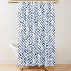 a blue and white shower curtain with wavy lines on the bottom, in front of a bathtub