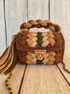 a brown and white handbag sitting on top of a wooden table next to a chain