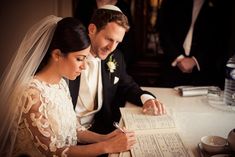 the bride and groom are signing their marriage vows