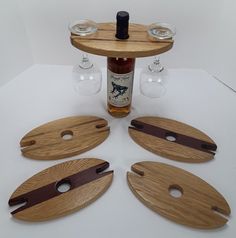 four wooden cutting boards sitting on top of a table next to two wine glasses and a bottle