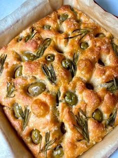 a square casserole with olives and rosemary