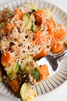 a white plate topped with zucchini, carrots and other veggies