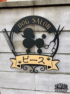 the dog salon sign has scissors and a comb on it