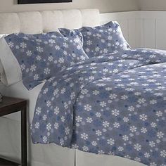 a bed with blue and white flowers on it